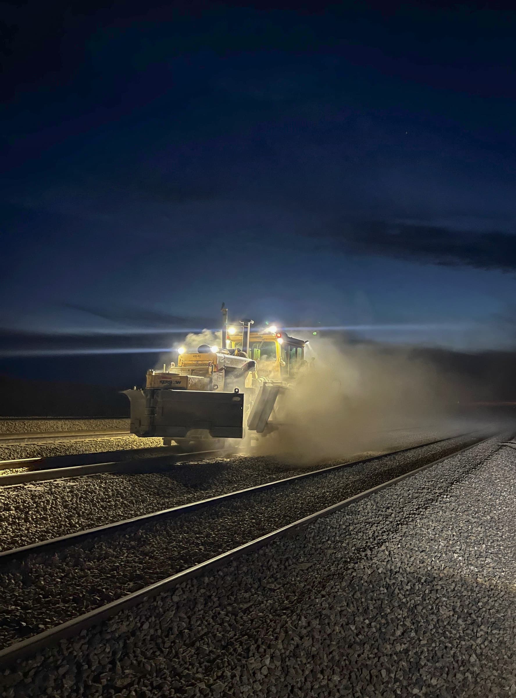 Railway surfacing equipment working under lights